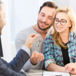 Deux clients rencontrent une agente dans une agence immobilière à Roanne pour discuter d’un projet de vente.