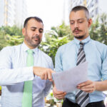 Deux agents en pleine discussion de dossier dans la meilleure agence immobilière à Nice